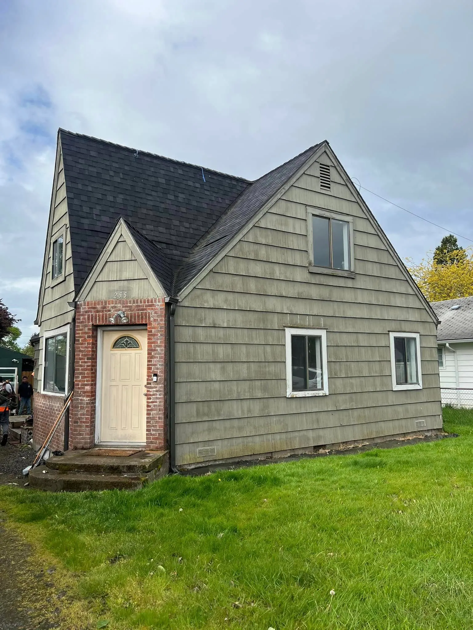 An older Cape Cod with weathered shake siding, before the work