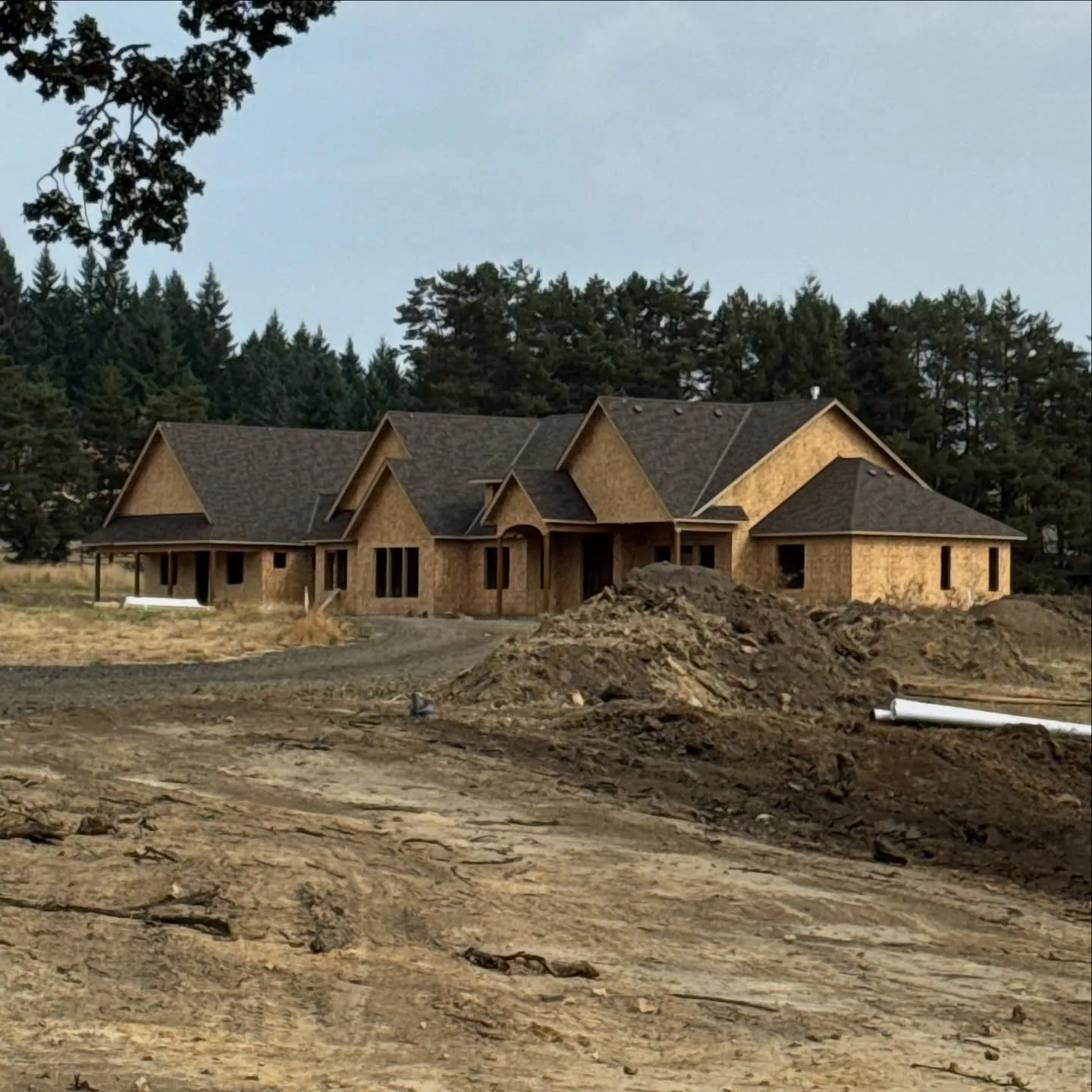 A large custom home framed and sheathed, waiting for roofing and siding